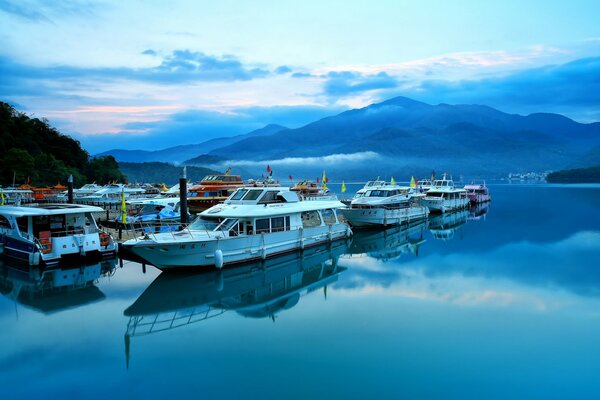 Pier with boats and boats on the background of mountains