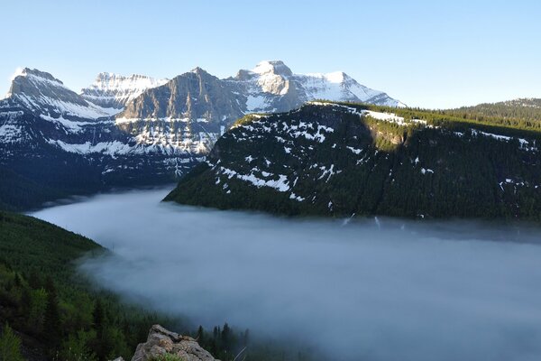 Misty forest on the background of mountain peaks