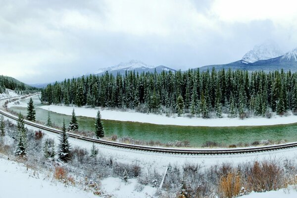 Ferrocarril a lo largo del río en Canadá en invierno