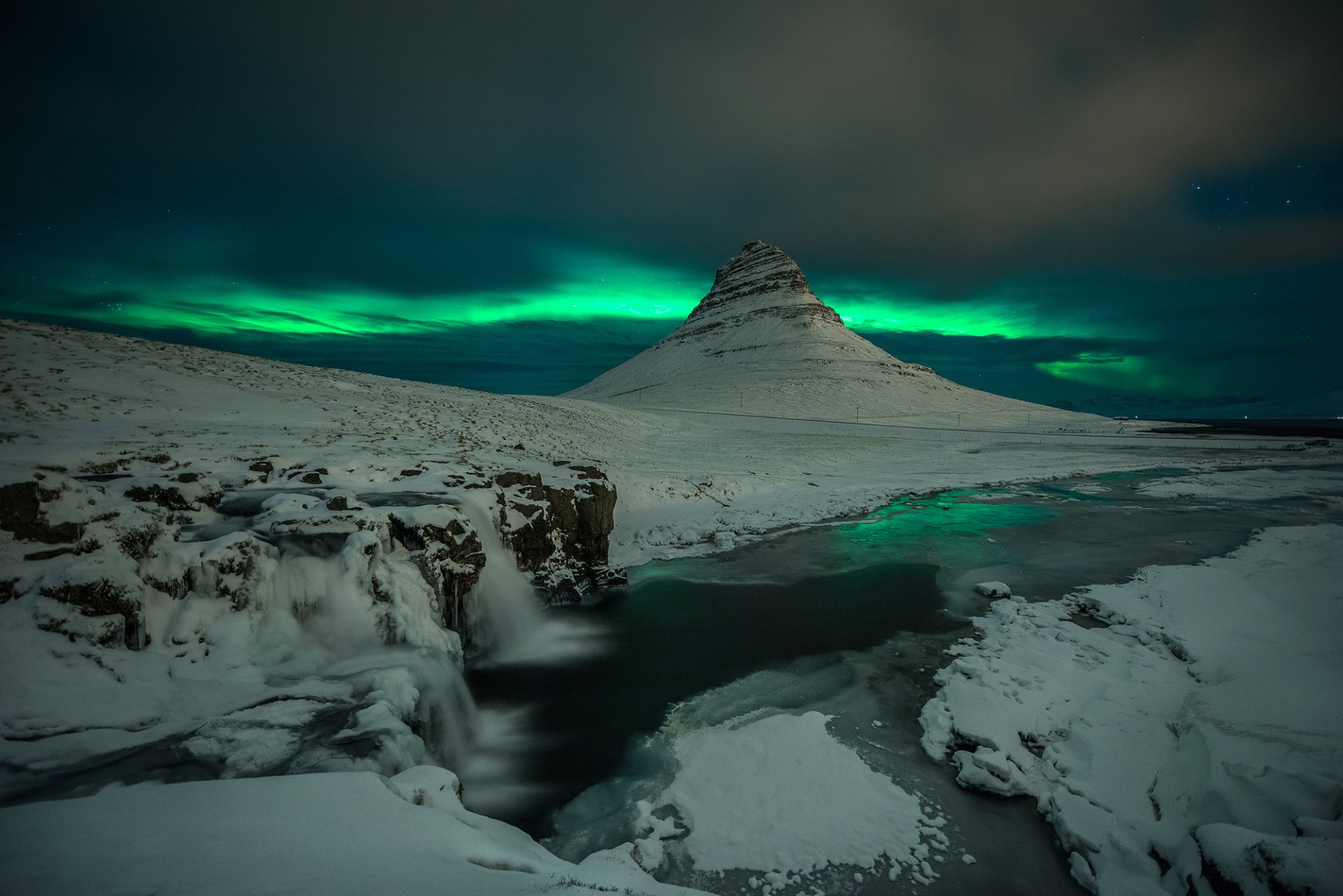 islanda kirkjufell montagna vulcano rocce cascata neve notte aurora boreale