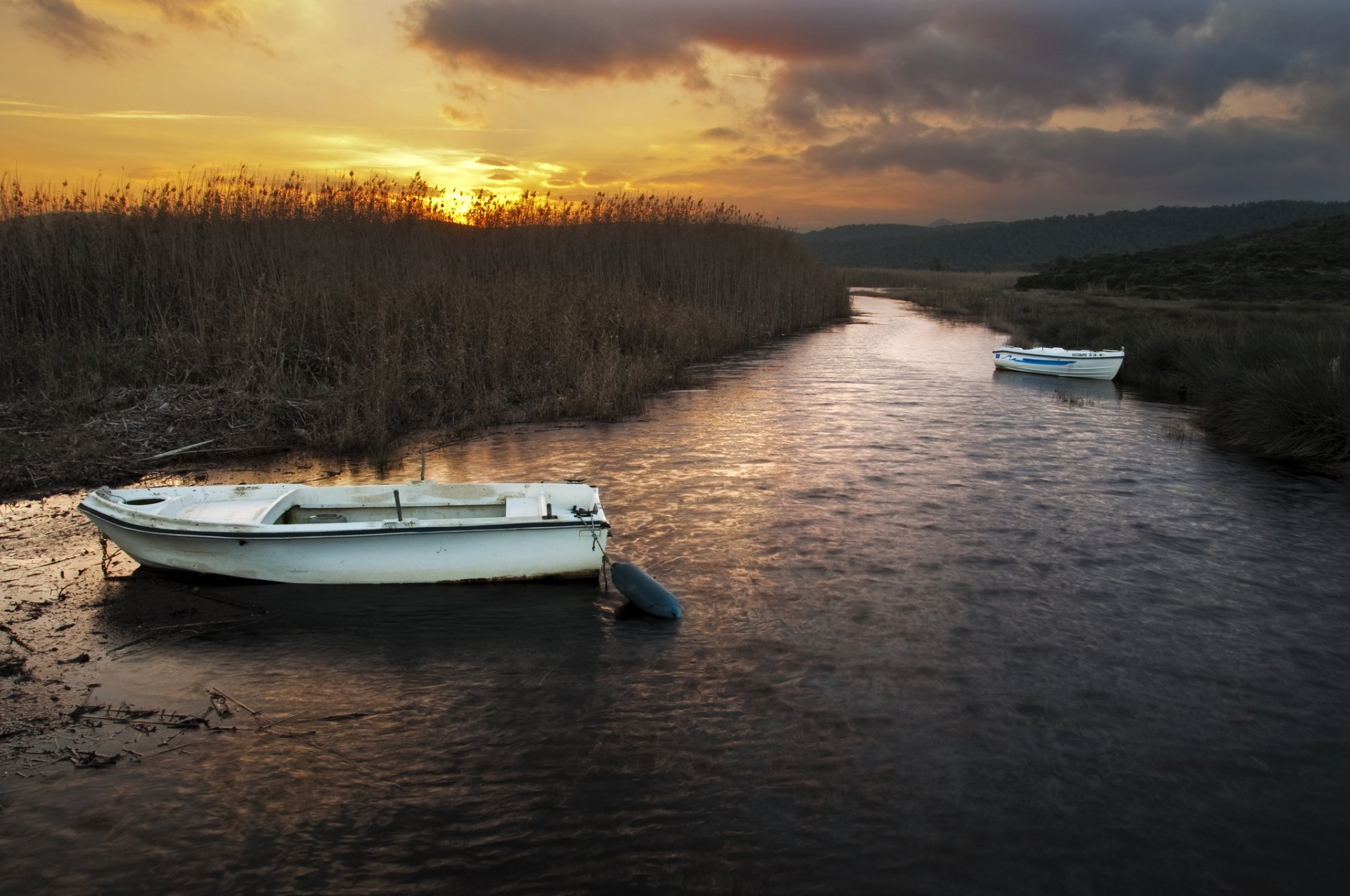 río cañas barcos puesta de sol