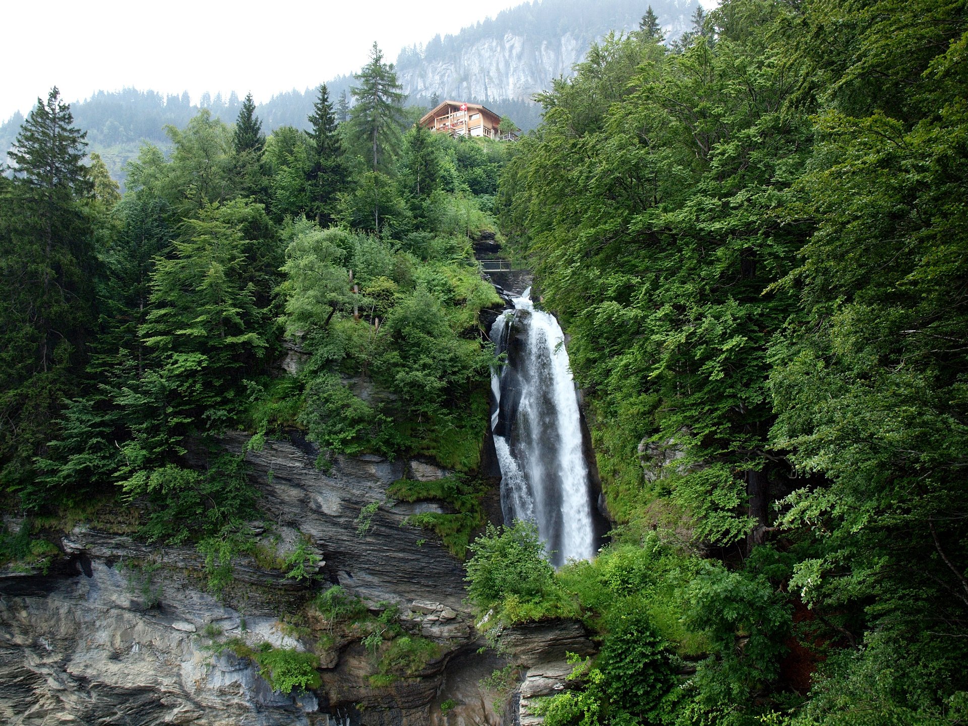 reichenbach svizzera cielo montagne alberi casa cascata