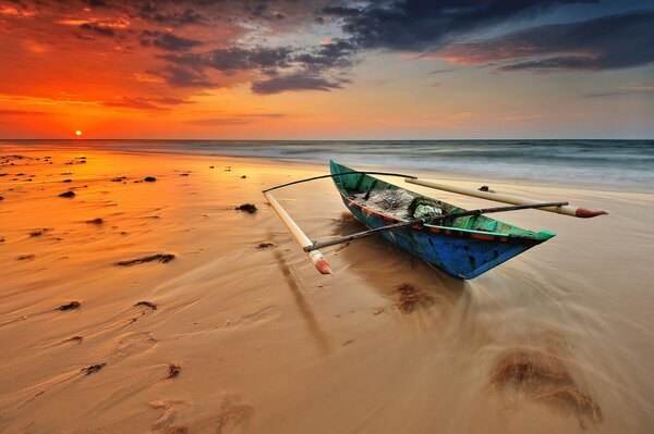 Lonely boat on a sandy beach in the evening