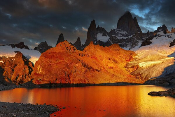 Alba su un lago circondato da montagne innevate