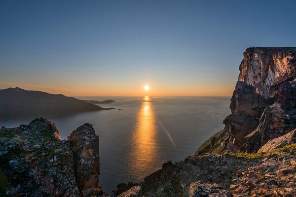 Sonnenuntergang vor dem Hintergrund der Berge und des Meeres