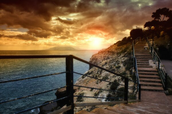 Treppen in einem Berg am Meer bei Sonnenuntergang