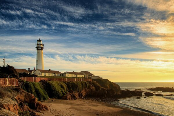 Amanecer en la playa del mar con un faro