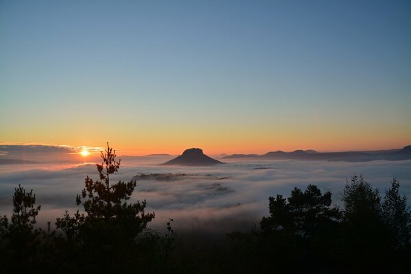 Montaña en la niebla, cielo al atardecer