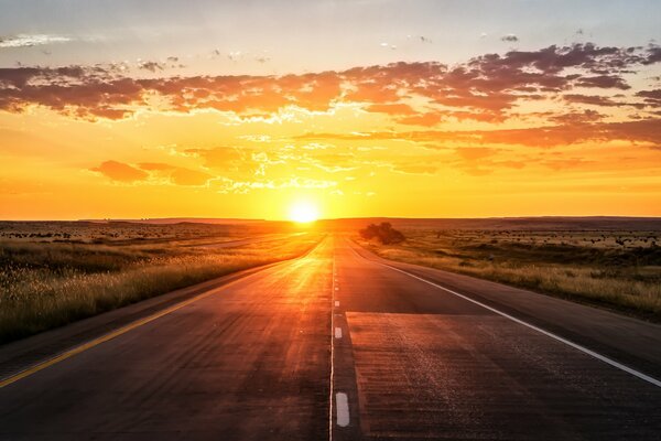 Coucher de soleil sur la route. champ. nuages d or