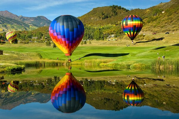 Luftballons fliegen über einen See in den Bergen