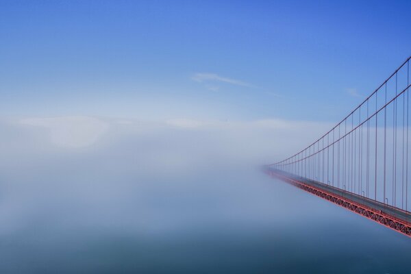 Puente colgante en la niebla temprano en la mañana