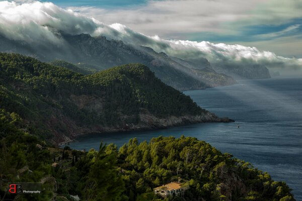 Una costa montañosa cubierta de nubes. Fotógrafo Burkhard