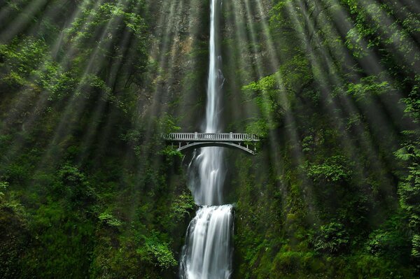 Ponte sulla cascata illuminato dai raggi del sole