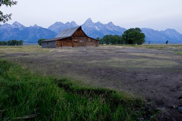 Haus im Feld vor dem Hintergrund der Berge