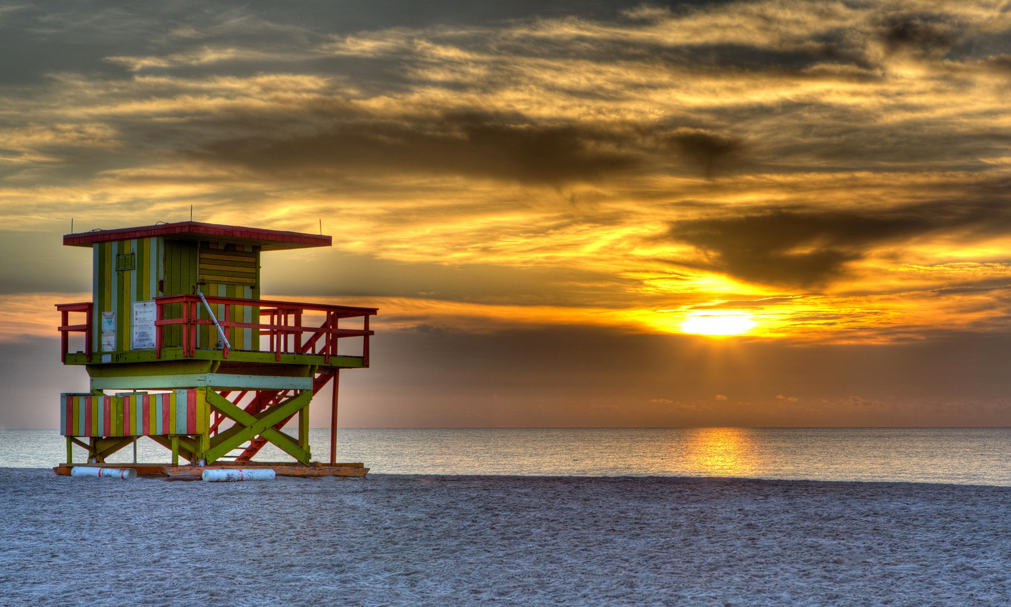 outh beach miami etats-unis soir coucher de soleil soleil ciel nuages mer océan sable plage tour maison