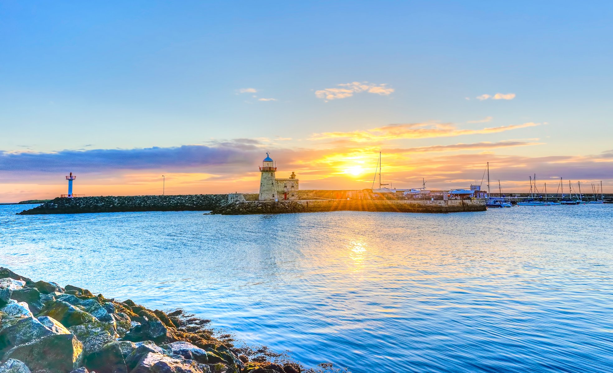 dublino irlanda cielo sole raggi tramonto faro mare nuvole pietre molo molo