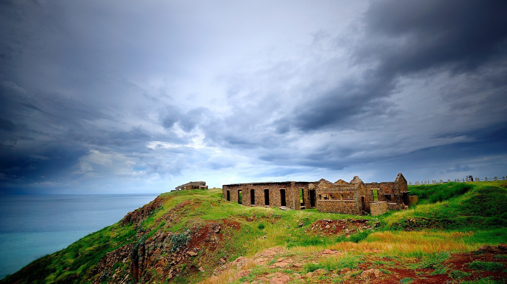 mare rovine collina erba case edifici