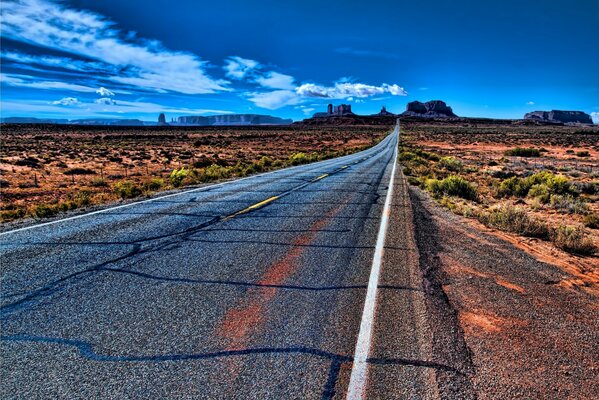 A highway in the middle of the desert leading to the city