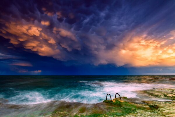 Ein bunter Himmel trifft auf ein helles Meer am Horizont