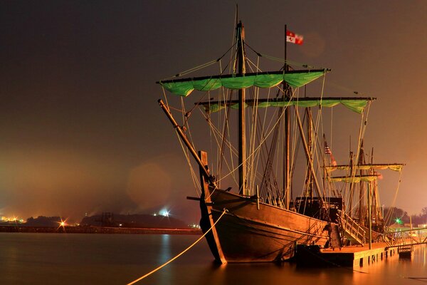 Barco en el mar por la noche cerca del muelle