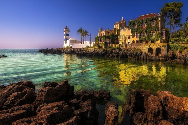 Villa with lighthouse in the sea bay