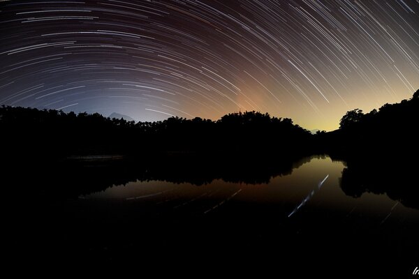 Unusual circles in the night sky on the lake