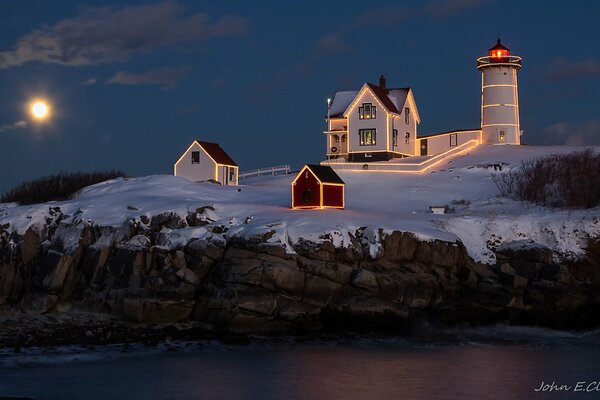 The light of a lighthouse in the night illuminates the way