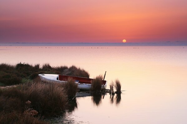 Bateau près du rivage au coucher du soleil