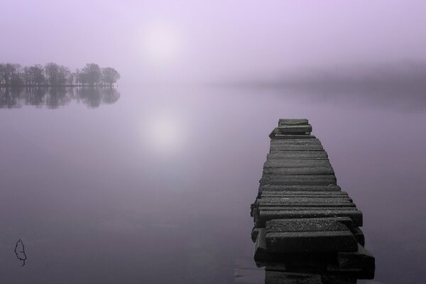 A bridge on a lake shrouded in fog