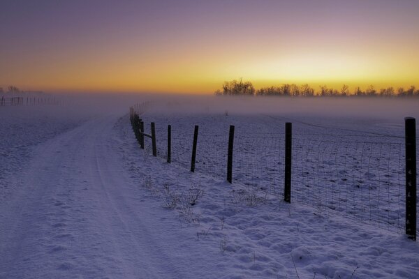 Frosty sunset in a field in the middle of snow