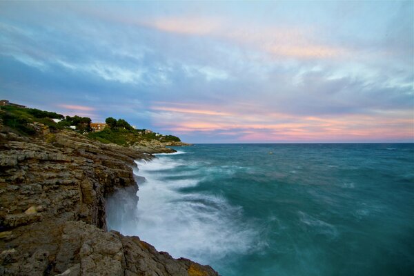 Nubes azules y Rosadas sobre las rocas y el mar