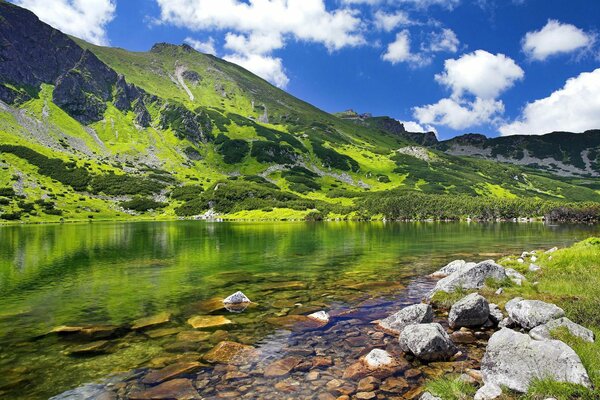 Montañas fabulosas, nubes, lago y piedras