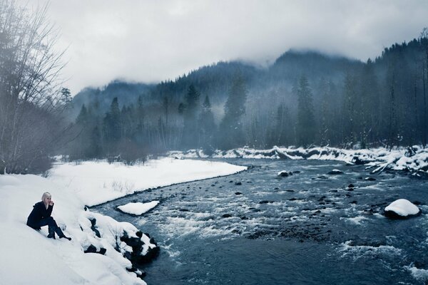 A girl on the shore of a winter ice lake