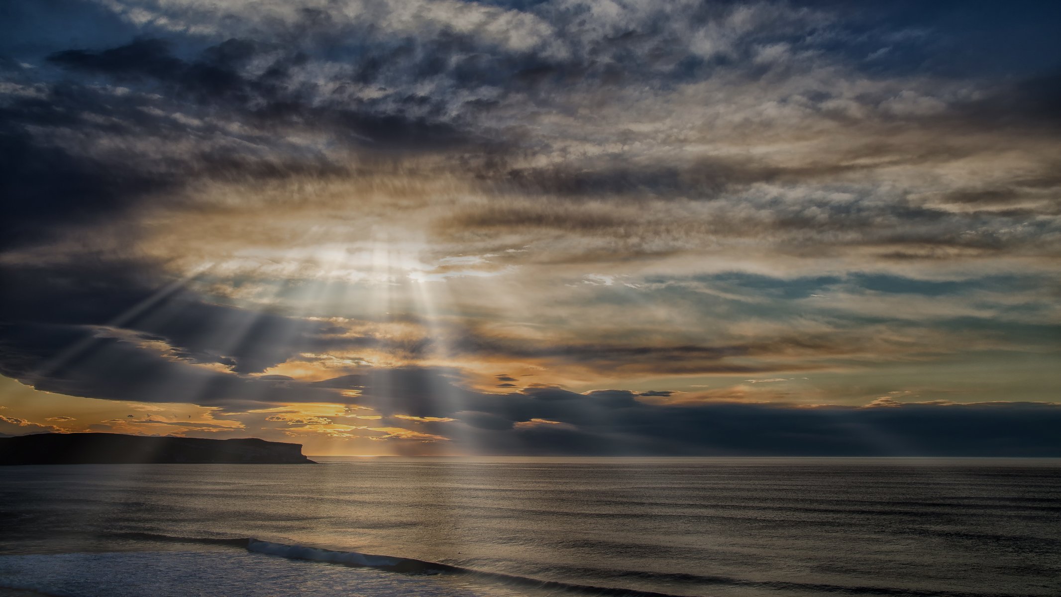 mare roccia nuvole raggi del sole