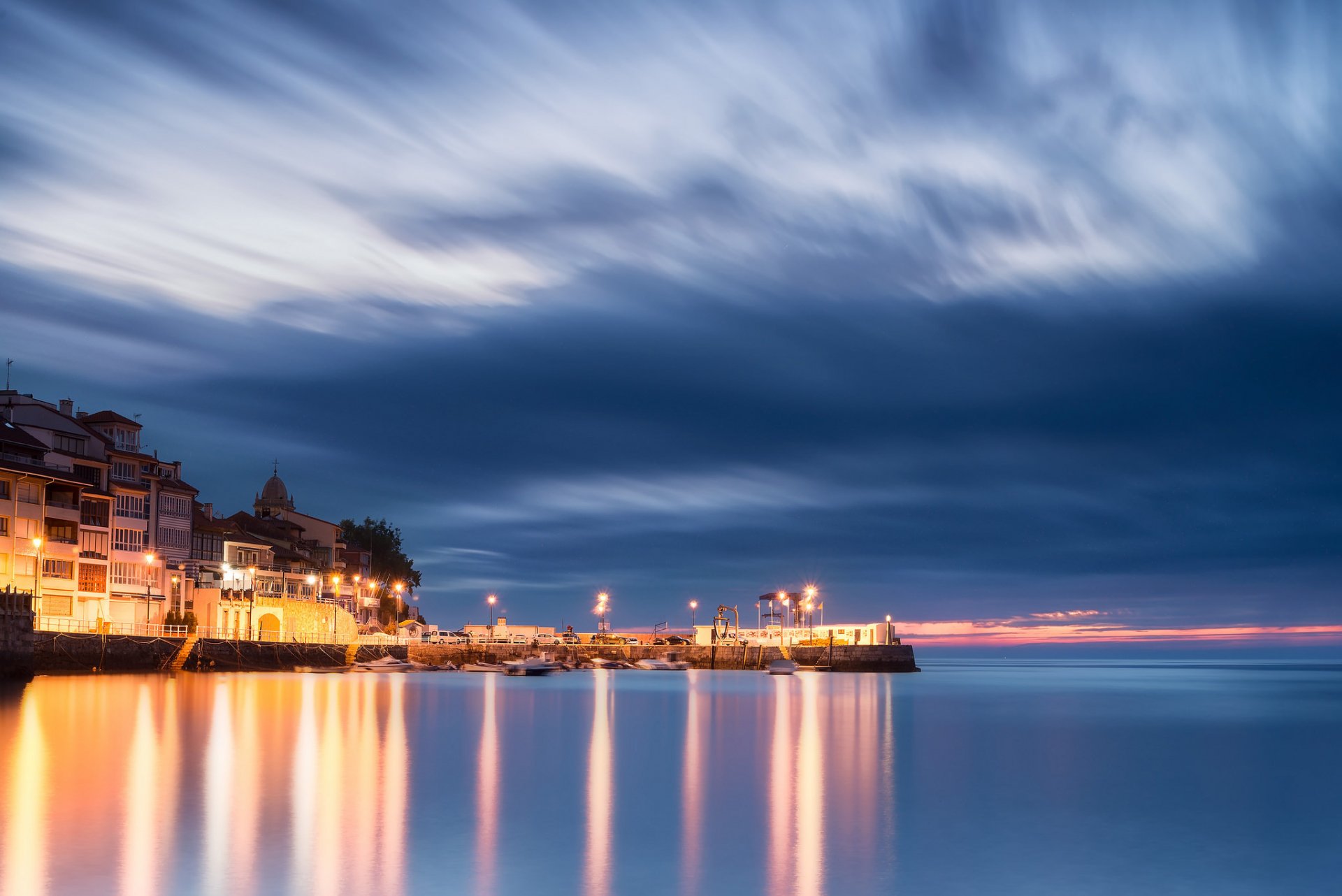 spagna asturie golfo di biscaglia porto case sera luci illuminazione lanterne blu cielo nuvole