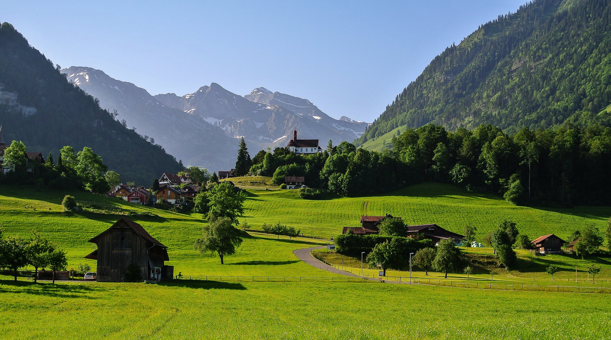 witzerland sky mountain alps valley grass road house tree