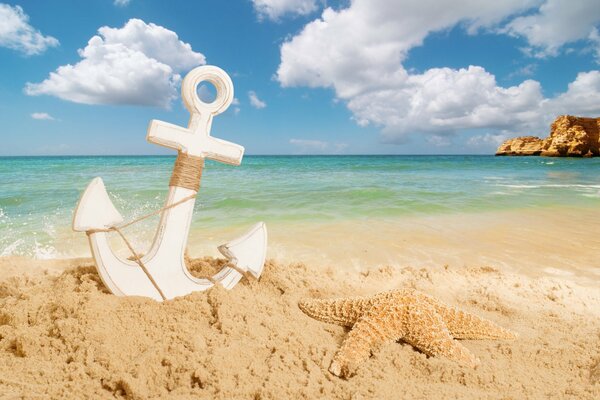 Ancre et étoile de mer sur la plage de sable