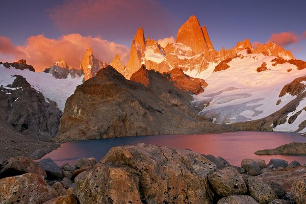 Berge mit Schnee um den See herum. Sonnenuntergang