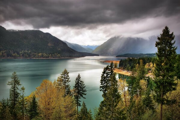 El sombrío cielo sobre el lago y el bosque