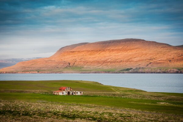 Icelandic house in a field by the bay