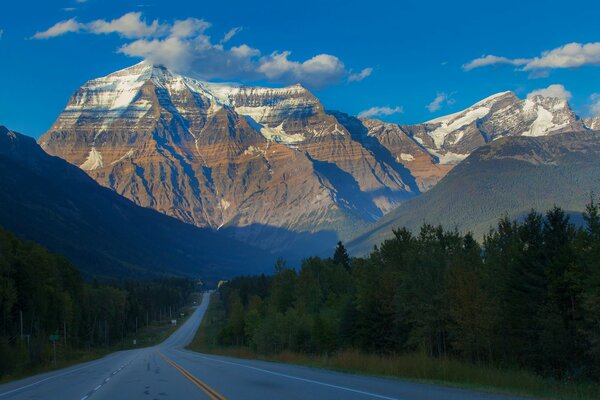 Snowy mountain top. A road in the forest. Canada