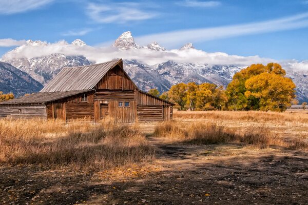 Casa de madera en las montañas con hermosas nubes