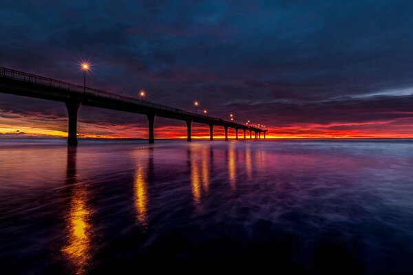 Beautiful sunrise in the light of lanterns on a pier in New Zealand