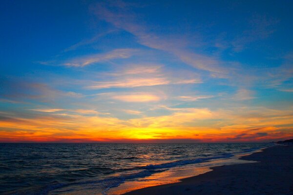 Hermosa puesta de sol en la playa junto al mar