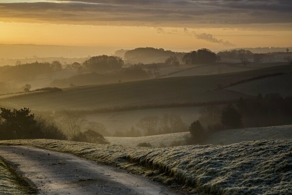 Route rurale et collines au coucher du soleil