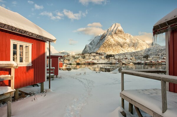 Casa invernale in riva al mare sullo sfondo delle montagne in Norvegia