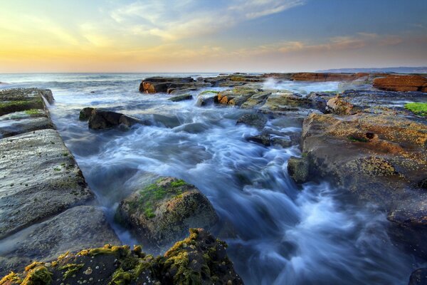 Wunderschöne Landschaft. Das tosende Meer unter den Steinen