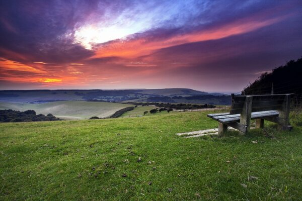 Sunset sky through the clouds bench green clearing