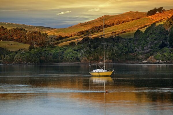 A boat on the lake. Hills and trees