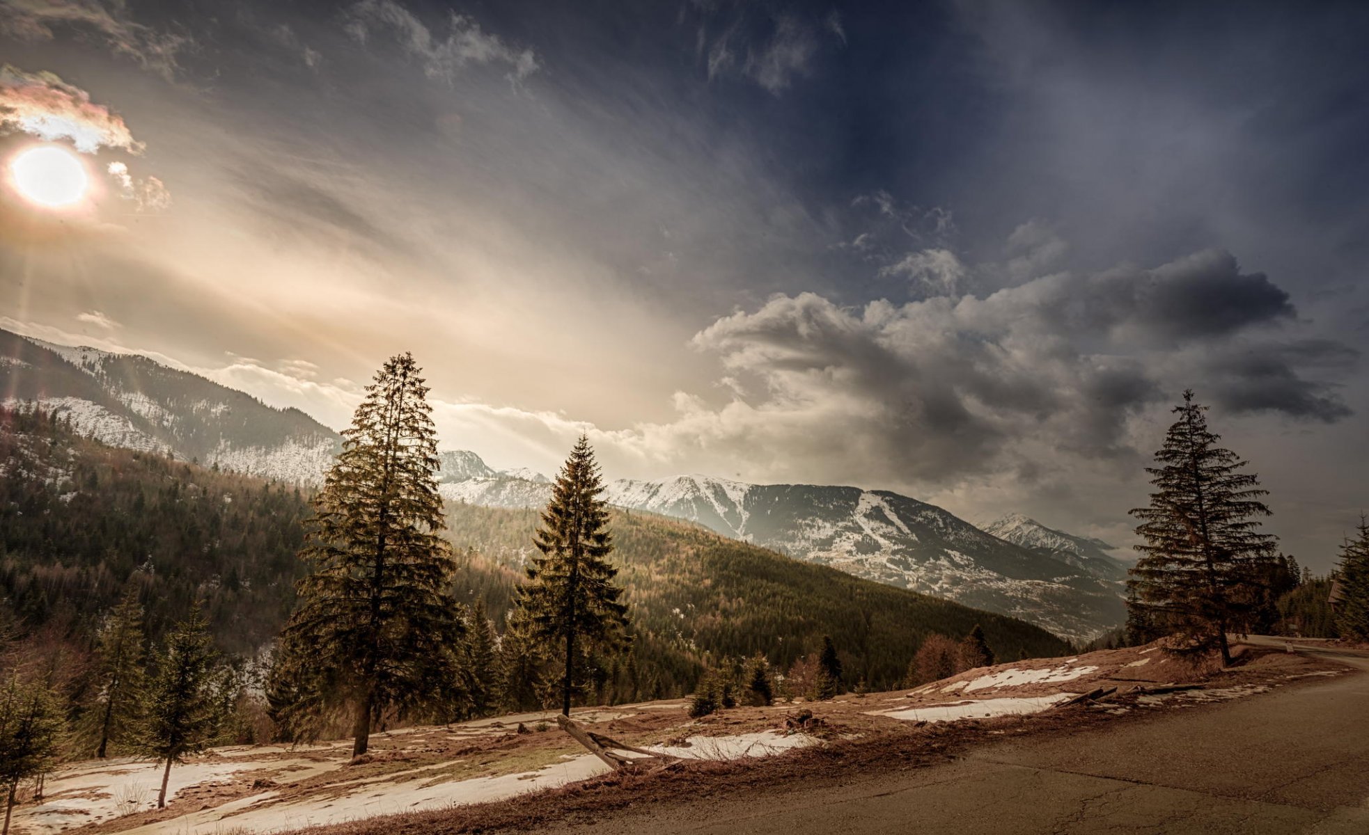 romania alberi montagne cime neve sole nuvole cielo strada pendenza paesaggio